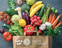Logo_mit_Bild_Let__s_eat_Ernaehrungsprogramm_klein.jpg Paper bag filled with various fresh vegetables and fruits with the text 'Let's eat' and 'Be smart against cancer' alongside a maze symbol